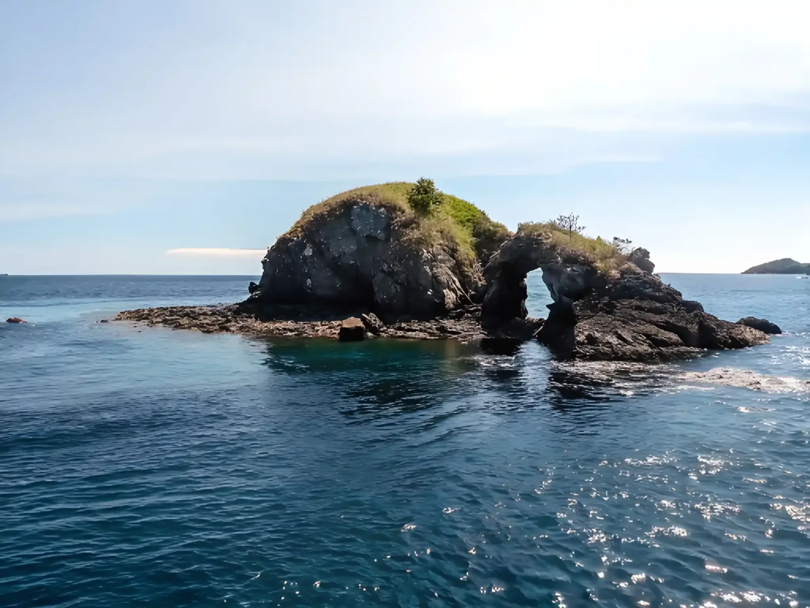 The pinnacle at Batu Bolong breaking the surface