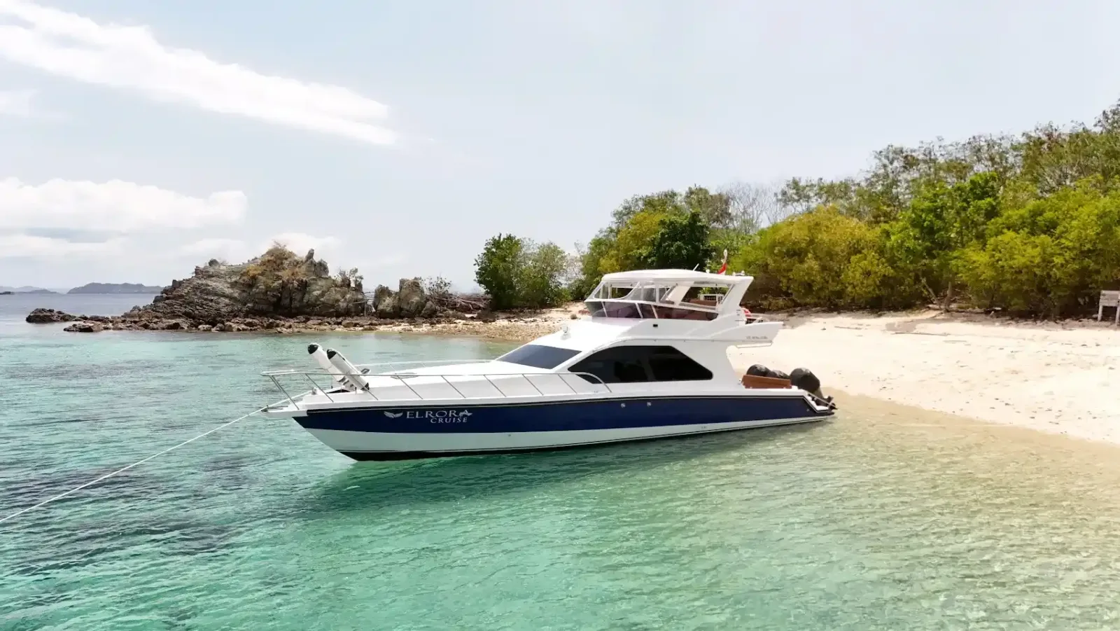 A motor yacht anchored off a beach