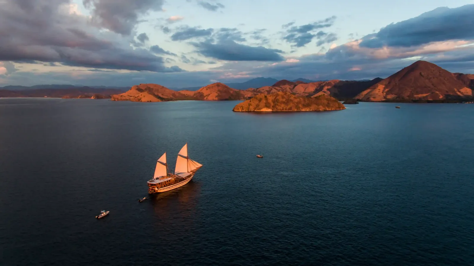 A phinisi at anchor at dusk, from the air