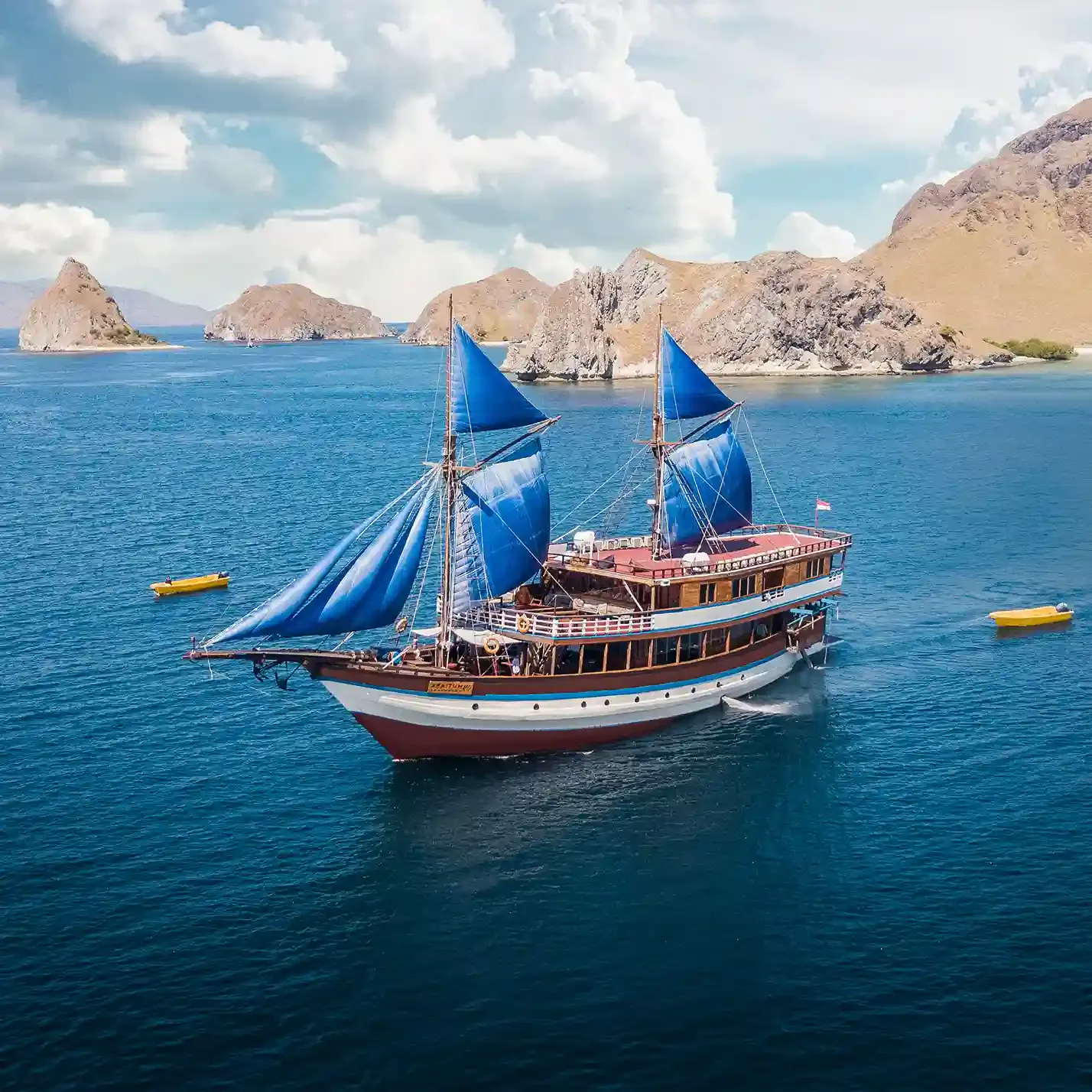 A phinisi with blue sails set