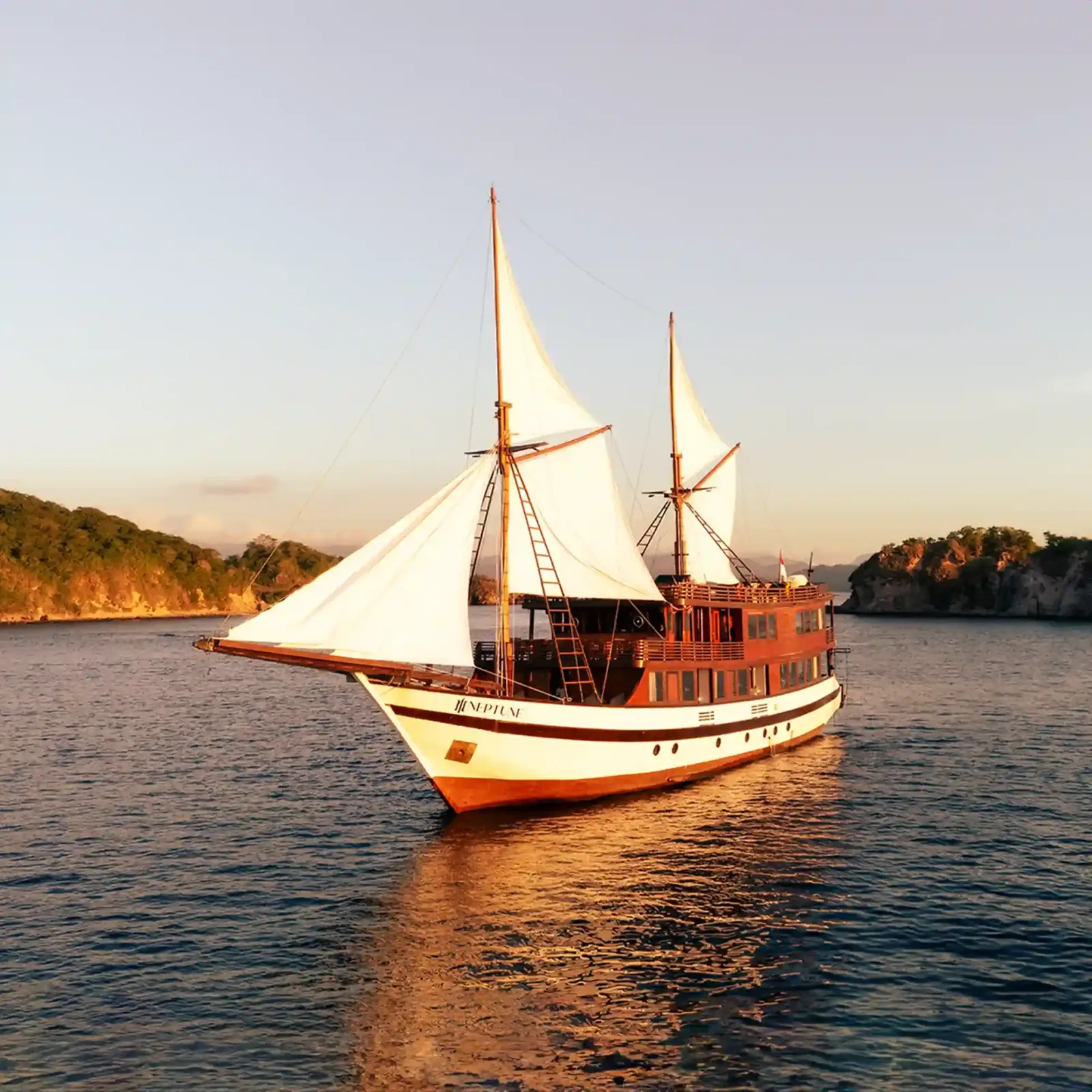 A phinisi at anchor in golden light