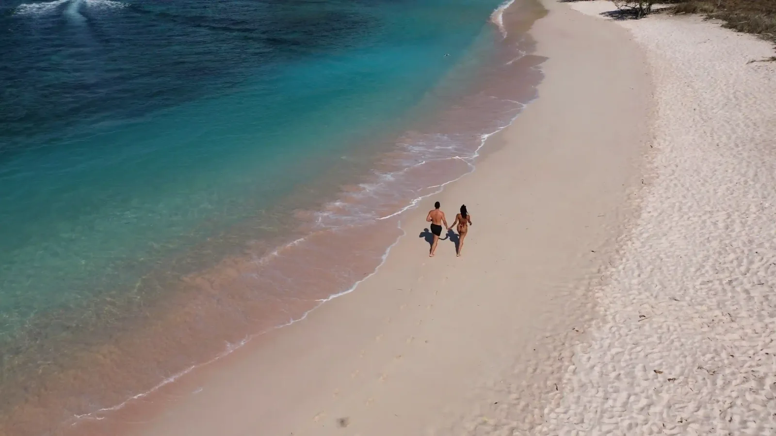 A couple on Pink Beach seen from above