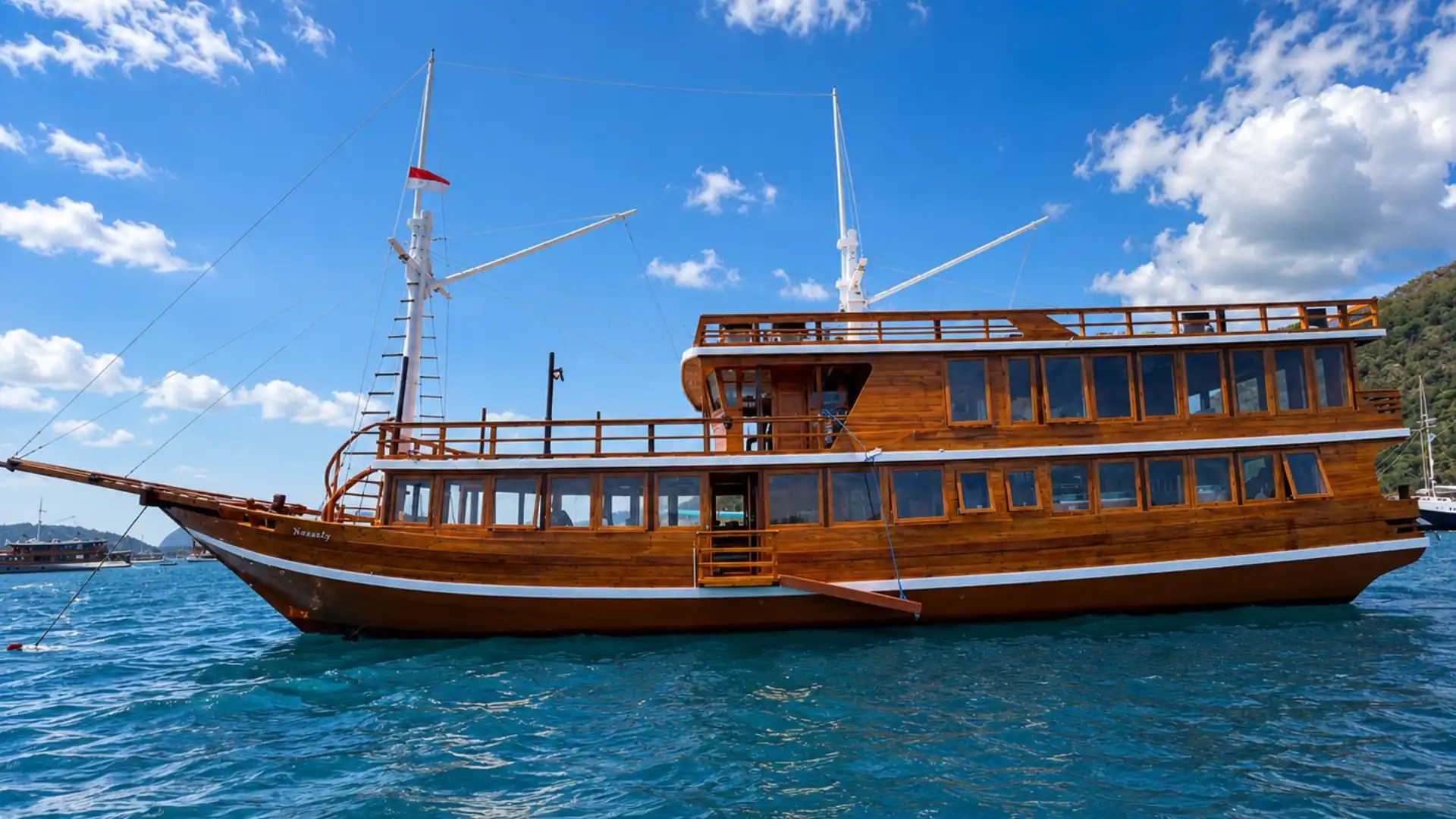 A phinisi under sail at sunset